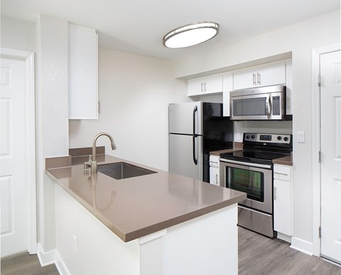 a kitchen with stainless steel appliances and white cabinets